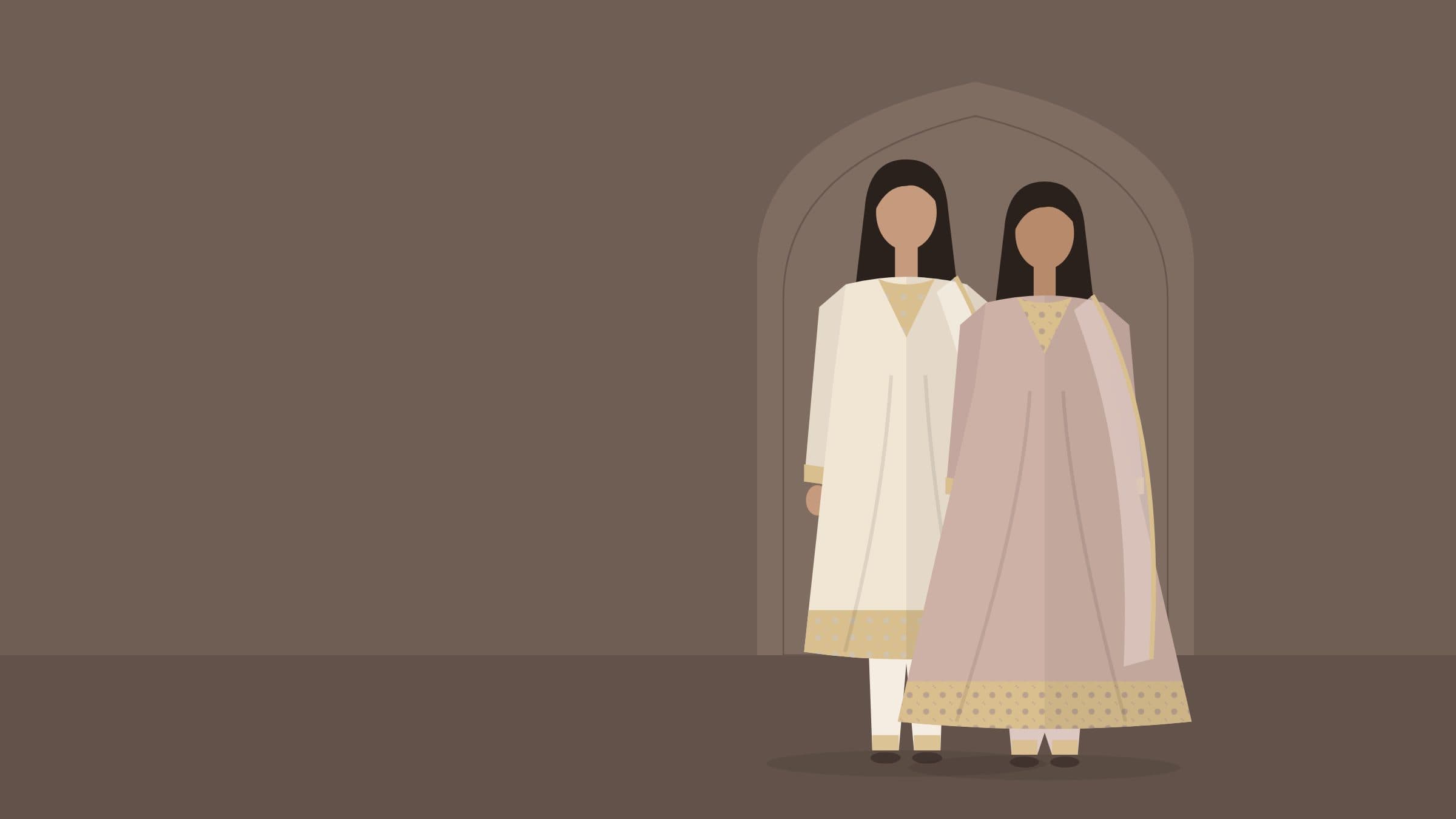 Two models in ivory and dusty rose embroidered suits standing beneath a carved Mughal arch